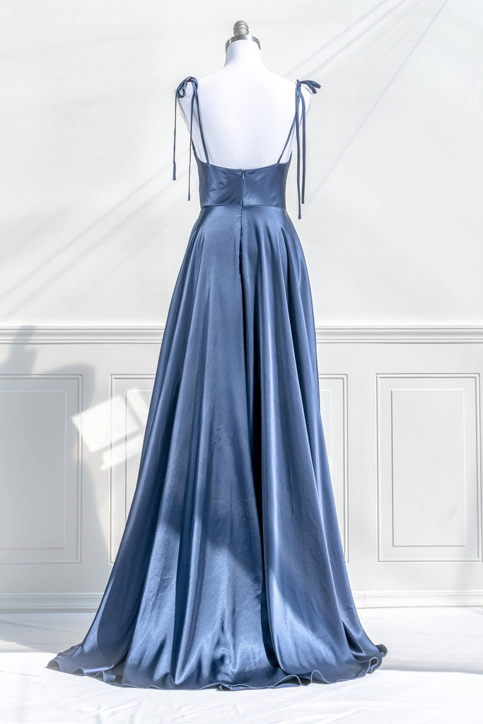 boutique dresses french style - a long blue satin prom dress, with a cowl neckline, spaghetti straps, and a stunning full sweeping gown skirt. back view. amantine.
