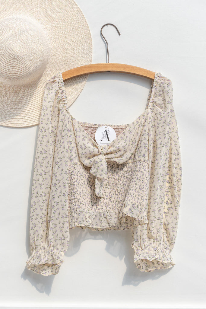 cottagecore outfit - a feminine and delicate blouse for women with bow front, long sleeves, and small floral print. hanger view. amantine. 
