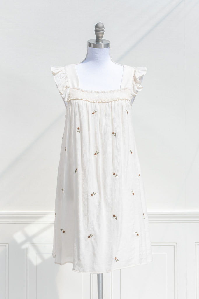 cottagecore dress - a sheath style chemise dress with small embroidered floral print on an off white flowy fabric. amantine cottage core dress. front view.