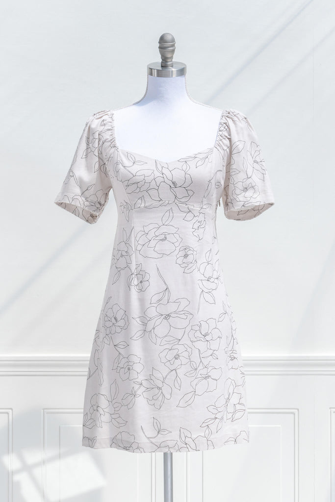 cottagecore dress - a mini dress with sweetheart neckline, short sleeves, side zipper, and graphic floral print on off white linen. front view. 