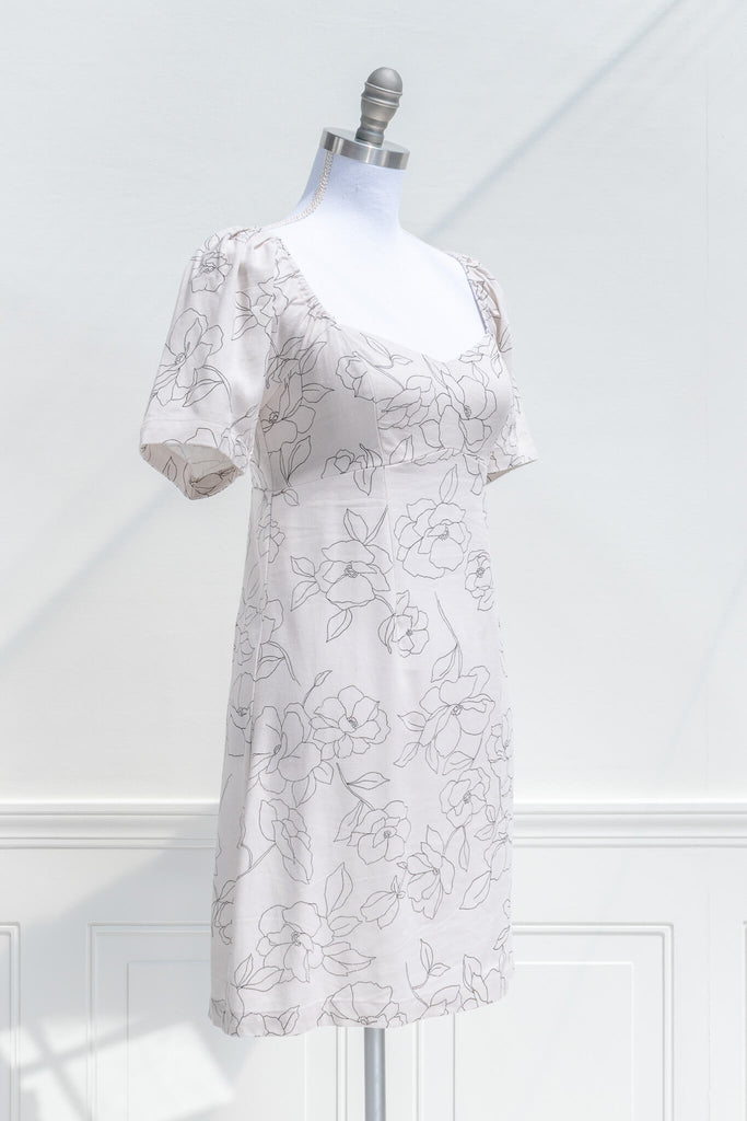 cottagecore dress - a mini dress with sweetheart neckline, short sleeves, side zipper, and graphic floral print on off white linen. quarter view. 