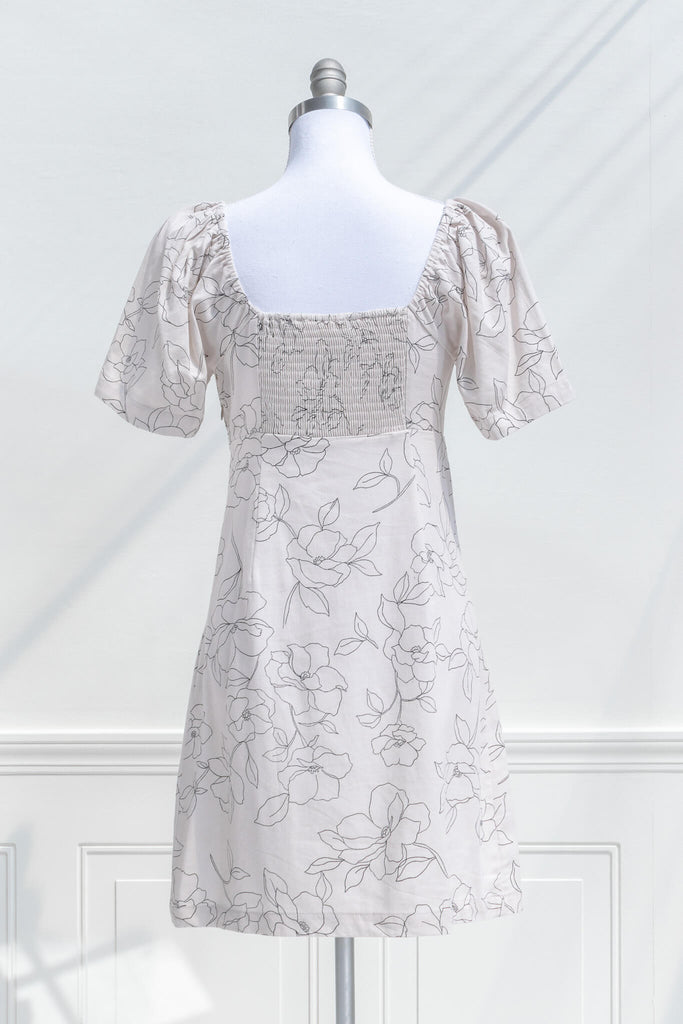 cottagecore dress - a mini dress with sweetheart neckline, short sleeves, side zipper, and graphic floral print on off white linen. back view. 