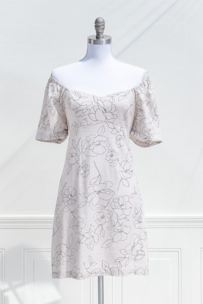 cottagecore dress - a mini dress with sweetheart neckline, short sleeves, side zipper, and graphic floral print on off white linen. view showing off shoulder style. 