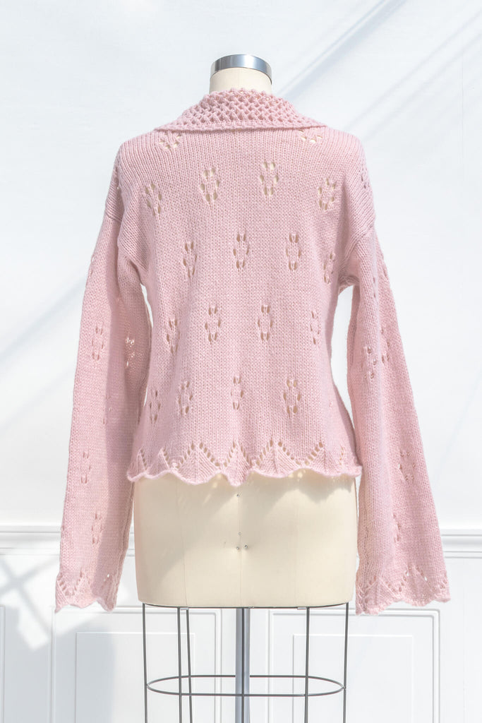 pink clothes - a pink button down cardigan with an oversized colar and oversized sleeves. feminine pink clothes. back view. 