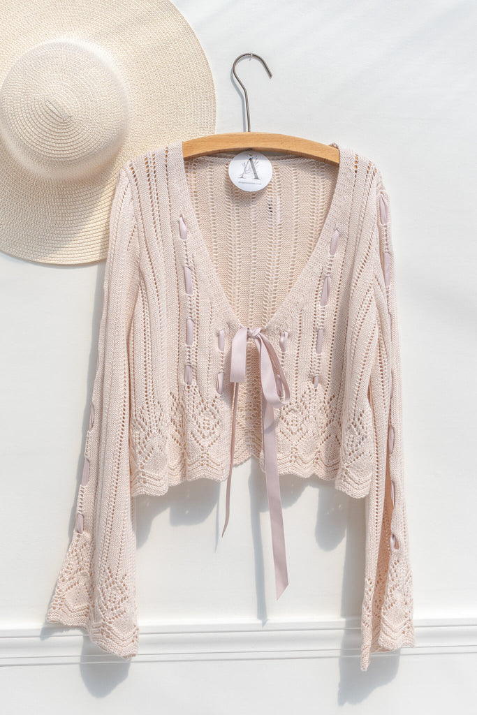 pink outfits - a beautiful and unique front tie cardigan with oversized sleeves and delicate knit details. hanger view. amantine. 