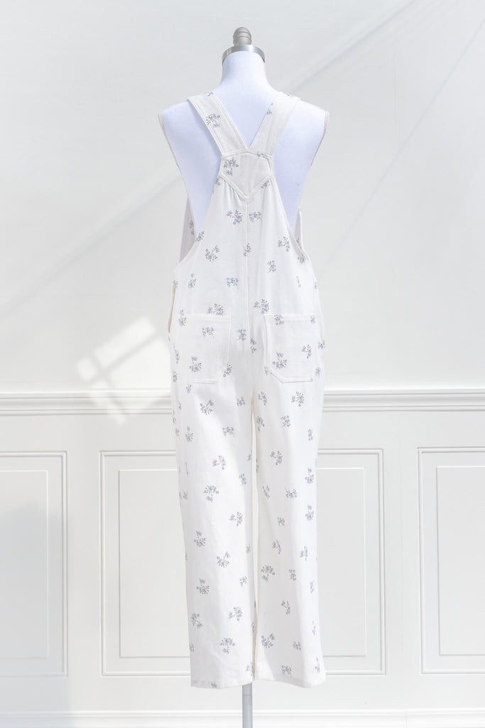 cottagecore outfits, a cottage core style jumpsuit, in white denim, small floral detail, and heart shaped applique detail. back view. amantine.