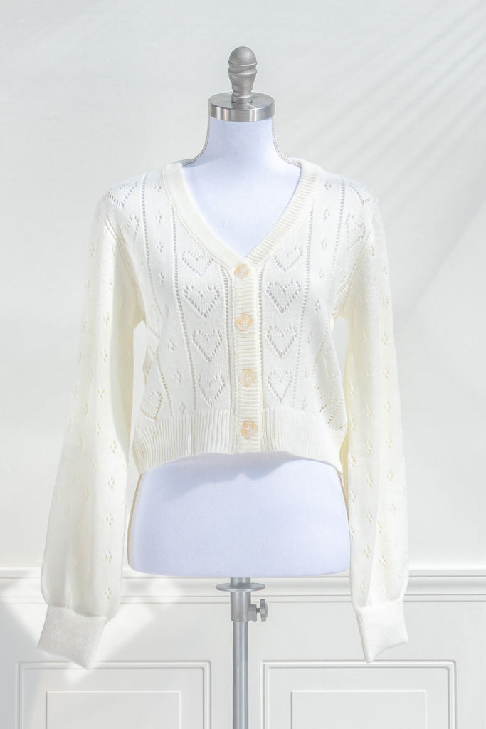 feminine tops - a french style cardigan sweater for spring. cream knit, button front, v neck, heart weave detail. front view. amantine. 