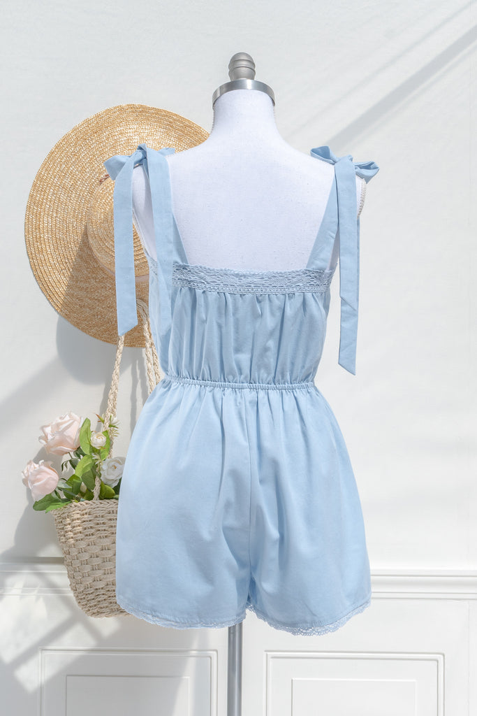 cottagecore style romper in periwinkle blue for spring time. with floral embroidery details and lace. back view. amantine. 