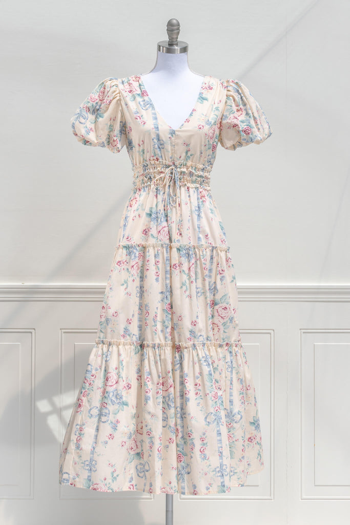 cottagecore dress - a beautiful v neck, puff sleeve, floral dress in feminine style. featuring blue and  mauve floral details on a beige fabric.front view. 