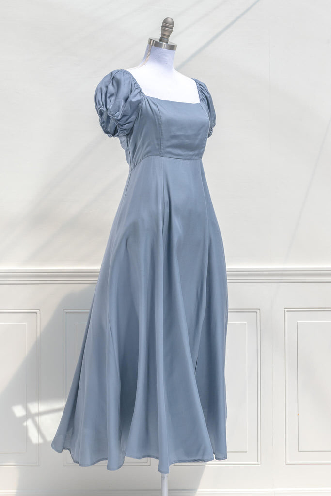 cottagecore dresses - a french inspired feminine dress in light blue, with puff sleeves, a line skirt, and high waistline - side quarter view. amantine.