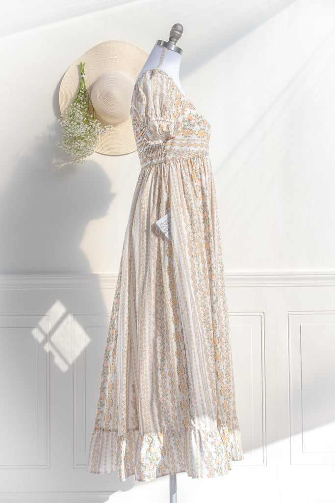 cottagecore dress with square neckline, puff sleeve, regency style, maxi length. Featuring a classic French vintage beige floral print. side view. Amantine.