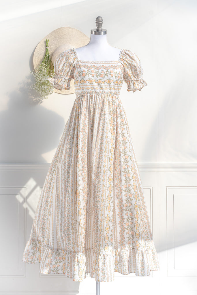 cottagecore dress with square neckline, puff sleeve, regency style, maxi length. Featuring a classic French vintage beige floral print. Front view. Amantine.