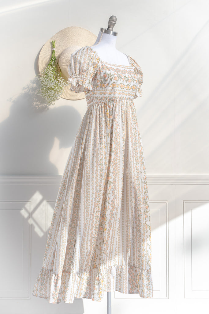 cottagecore dress with square neckline, puff sleeve, regency style, maxi length. Featuring a classic French vintage beige floral print. Front view. Amantine.