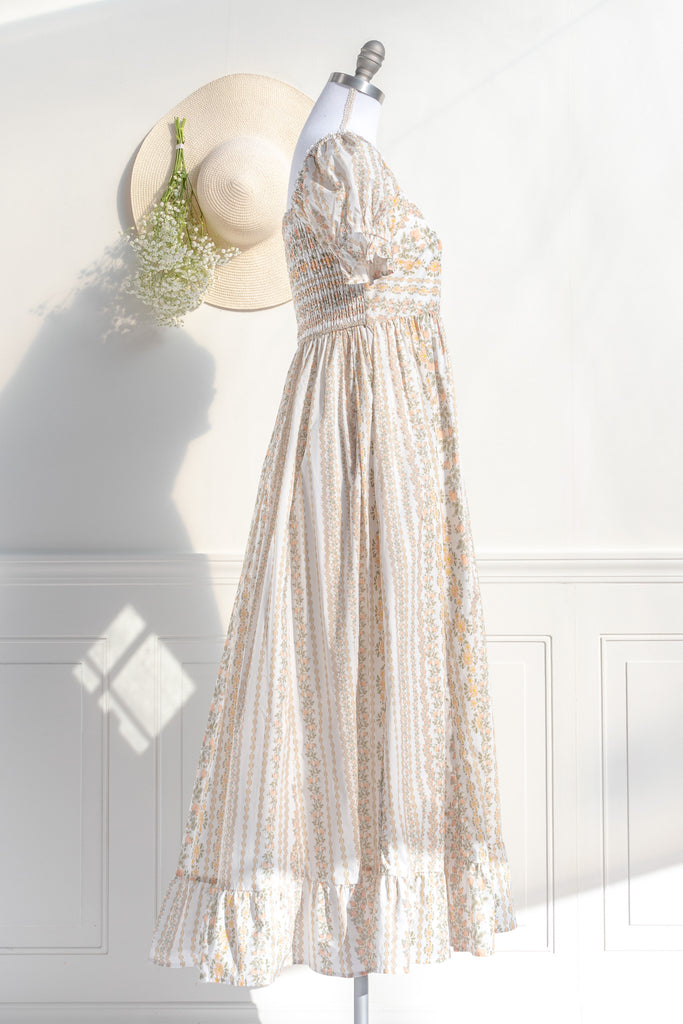 cottagecore dress with square neckline, puff sleeve, regency style, maxi length. Featuring a classic French vintage beige floral print. side view. Amantine.