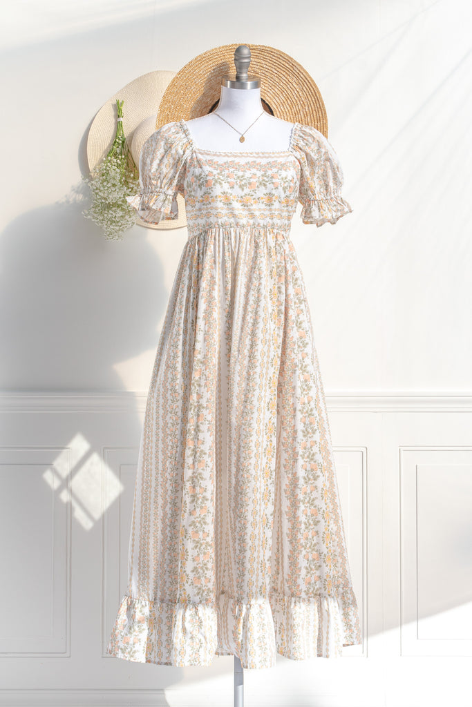 cottagecore dress with square neckline, puff sleeve, regency style, maxi length. Featuring a classic French vintage beige floral print. Front view. Amantine.