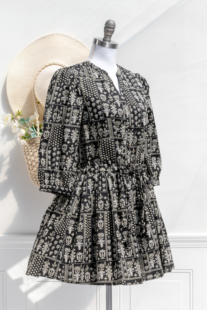 cottagecore dresses in our cottage romance collection.pretty cottagecore mini dress - modest style. featuring a boho print on black fabric. long sleeves. v neckline. 3/4 side view. 