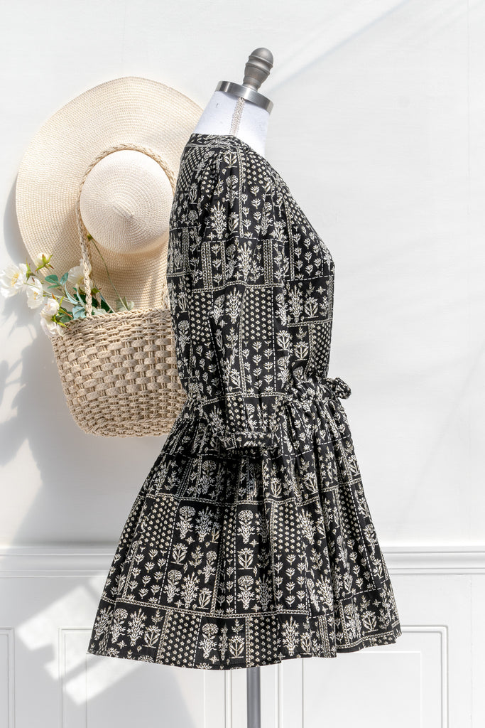 cottagecore dresses in our cottage romance collection.pretty cottagecore mini dress - modest style. featuring a boho print on black fabric. long sleeves. v neckline. side view. 