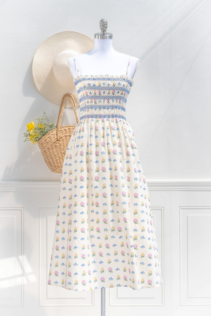 cotton cottagecore dress - a cream floral strap dress with ruched bodice, pockets, and an a line skirt. front view. 