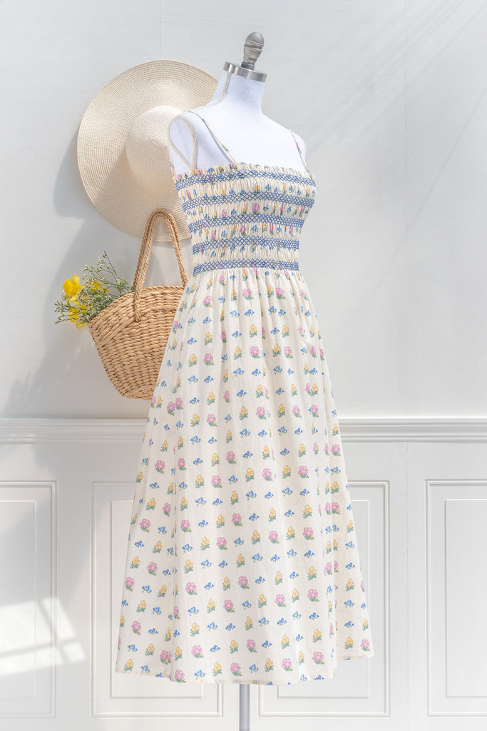 cotton cottagecore dress - a cream floral strap dress with ruched bodice, pockets, and an a line skirt. 3/4 side view. 