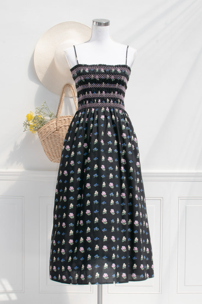 cotton cottagecore dress - a black floral strap dress with ruched bodice, pockets, and an a line skirt. front view. 