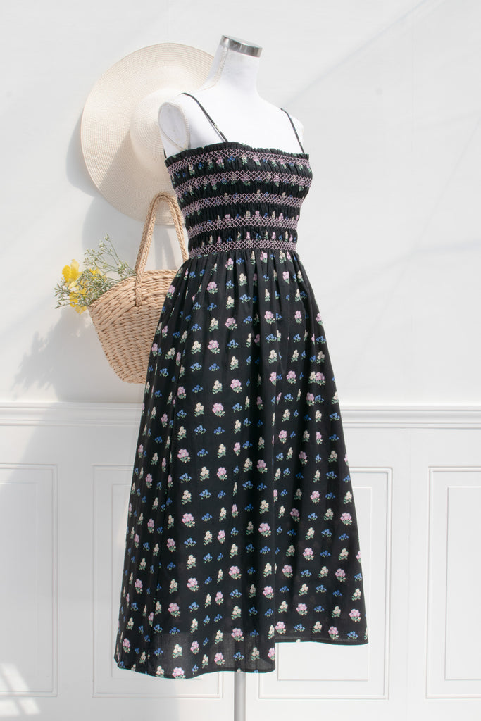 cotton cottagecore dress - a black floral strap dress with ruched bodice, pockets, and an a line skirt. 3/4 side view. 