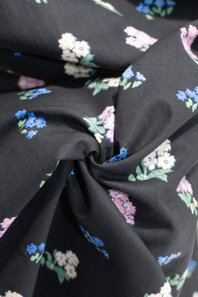 cotton cottagecore dress - a black floral strap dress with ruched bodice, pockets, and an a line skirt. up close fabric view showing floral details. 
