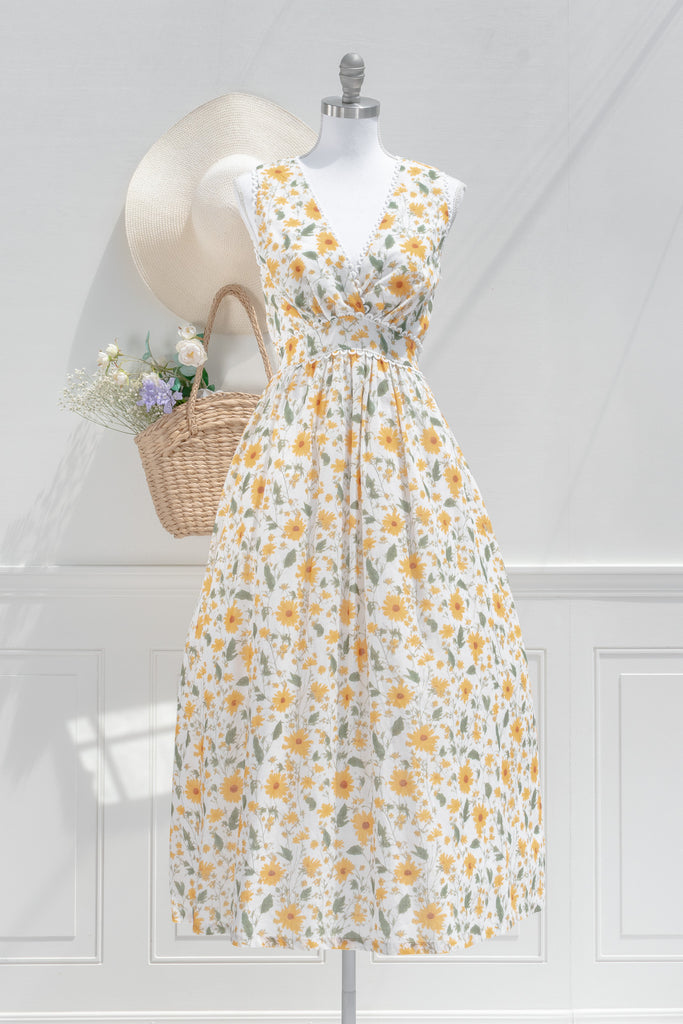 cottagecore dress - in yellow and green floral print. v neckline, sleeveless with ruched waist, and tie back. it has pockets and an aline skirt. pretty dress. front view. amantine. 