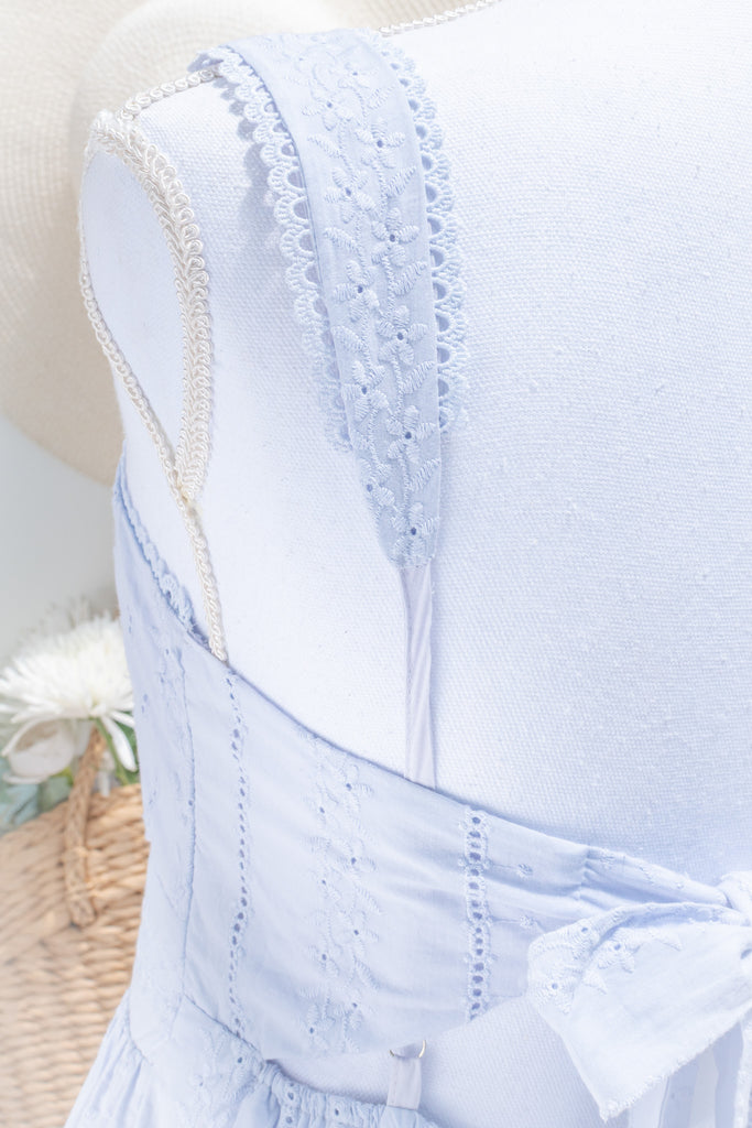 a 100% cotton dress featuring romantic eyelet lace fabric, a higher waistline for a regency-inspired silhouette, a flattering square neckline. A perfect cottagecore and castlecore aesthetic. strap view. amantine.