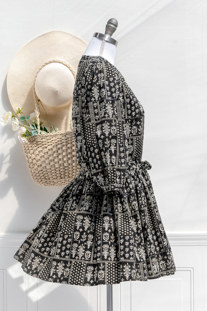 cottagecore dresses in our cottage romance collection.pretty cottagecore mini dress - modest style. featuring a boho print on black fabric. long sleeves. v neckline. side view. 