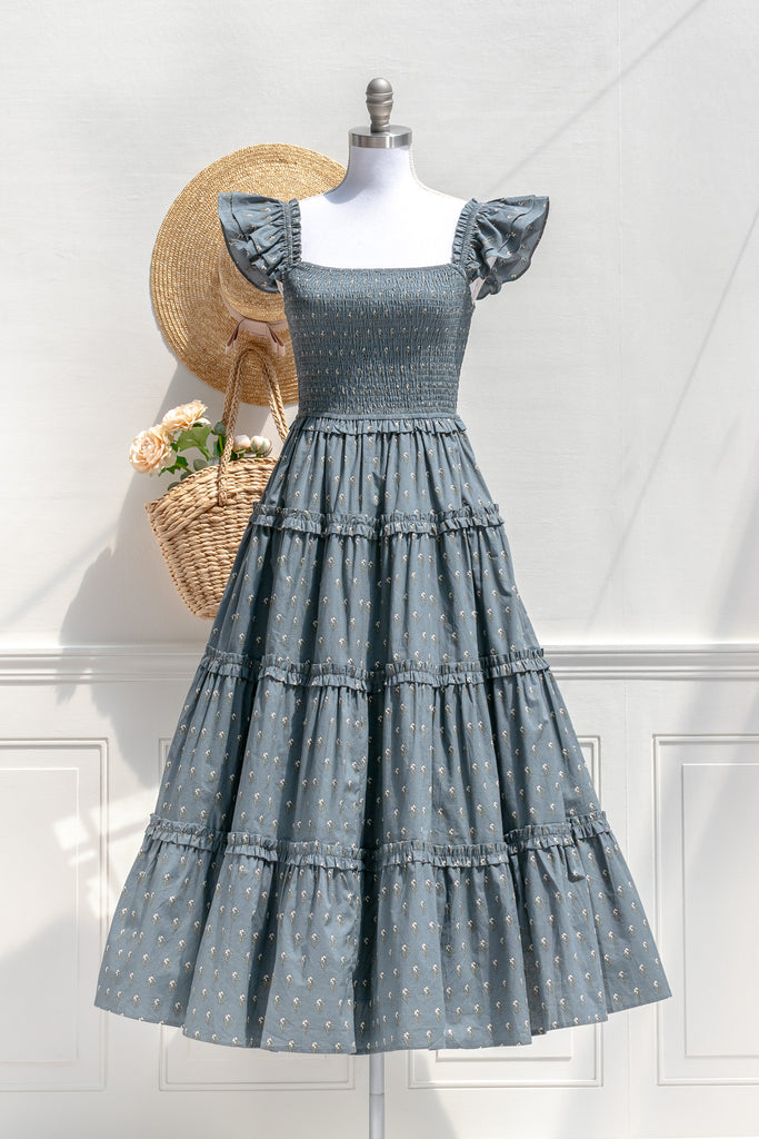 Amantine Camille dusty blue floral smocked midi dress with ruffled shoulders and tiered skirt — front view with billowing skirt