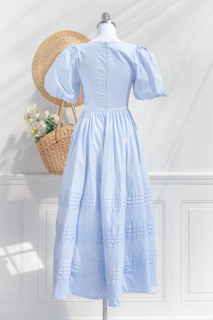 blue cottagecore dress - soft cotton dress with round neckline, puff sleeves, side pockets, and a long a line skirt. perfect for brunches in springtime. back view. 