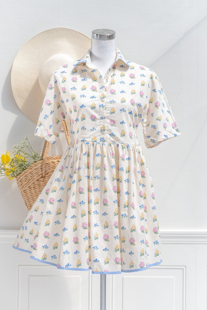 a pretty spring time midi dress - button down short sleeve floral mini dress. with pretty colorful floral details, blue trim, and in cottagecore style. front view. 