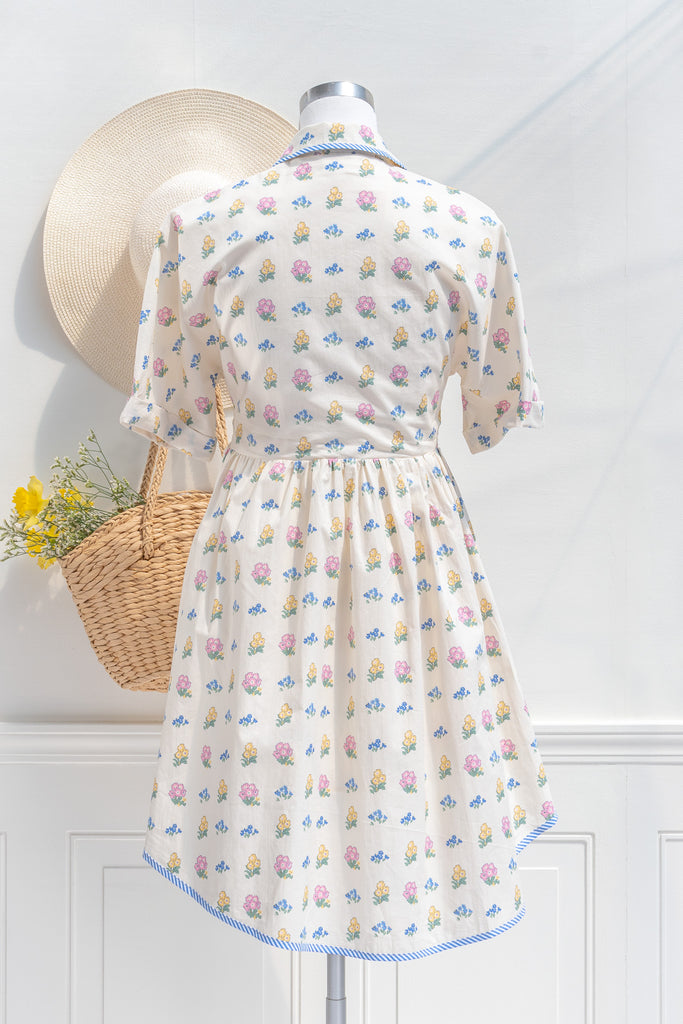 a pretty spring time midi dress - button down short sleeve floral mini dress. with pretty colorful floral details, blue trim, and in cottagecore style. back view. 