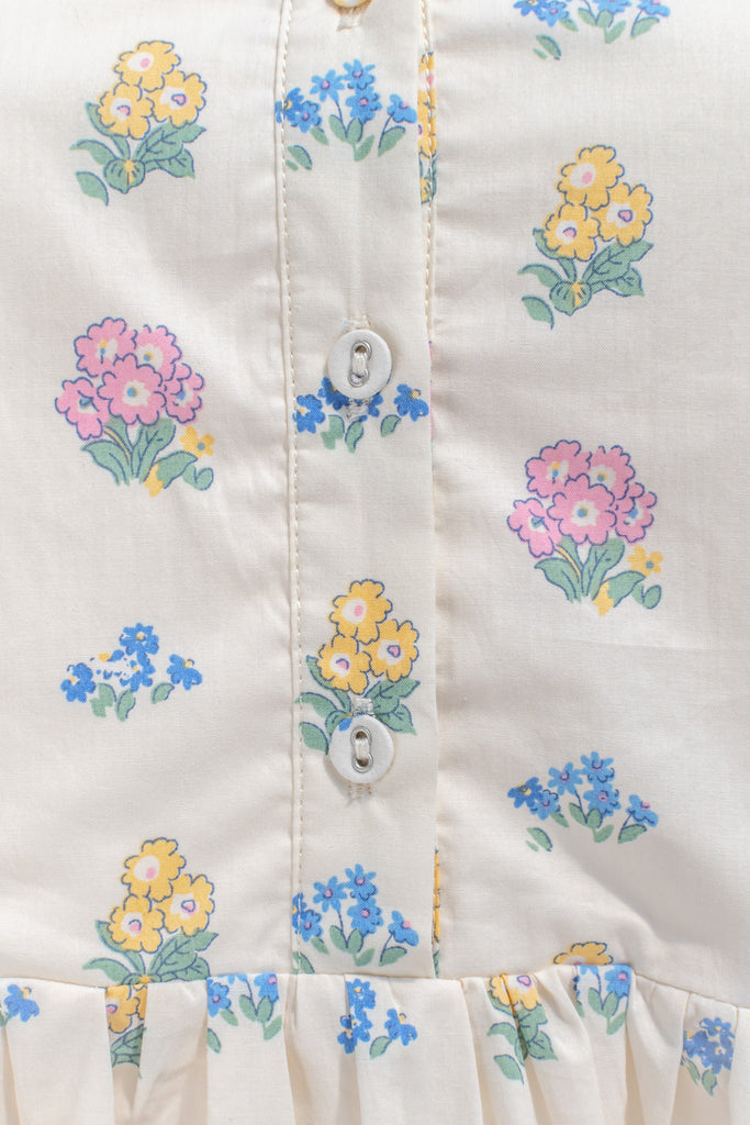 a pretty spring time midi dress - button down short sleeve floral mini dress. with pretty colorful floral details, blue trim, and in cottagecore style. upclose fabric view. 