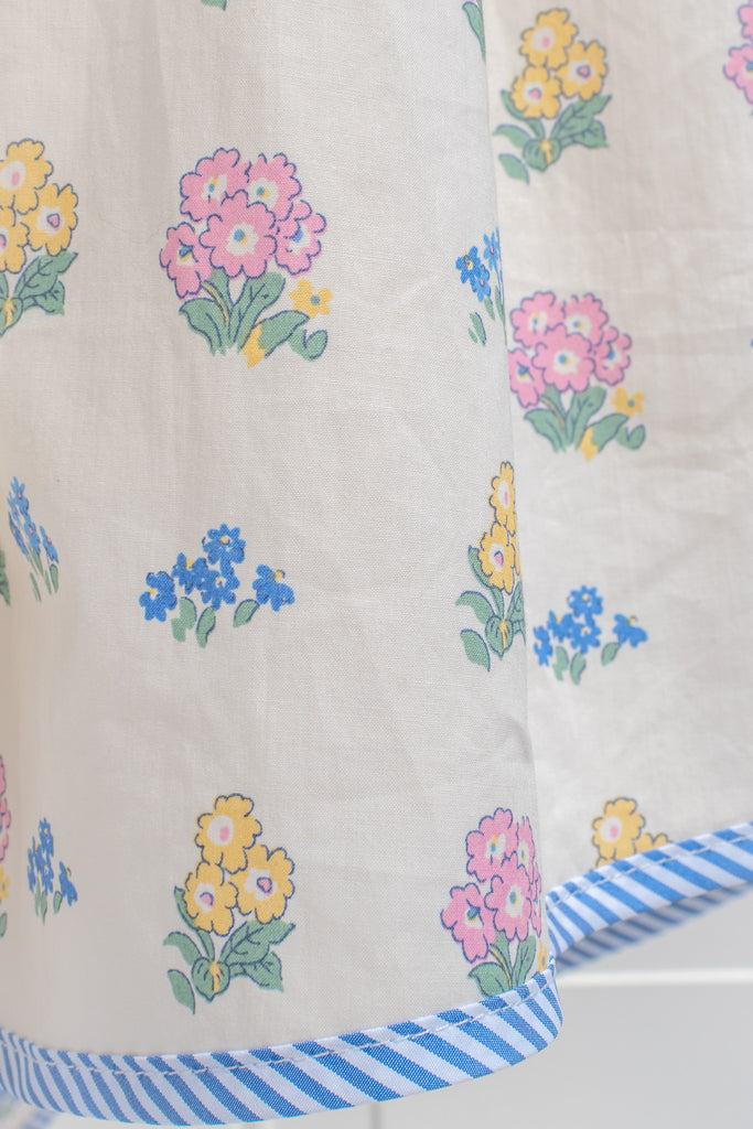 a pretty spring time midi dress - button down short sleeve floral mini dress. with pretty colorful floral details, blue trim, and in cottagecore style. front view. 