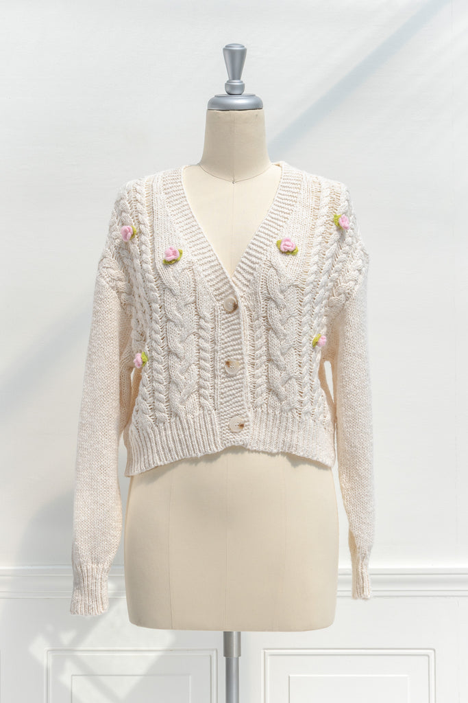 cute sweaters - a vanilla cable knit cardigan with pink and green rose details in 3d. Cottagecore sweater outfit for fall. Front view. Amantine. 