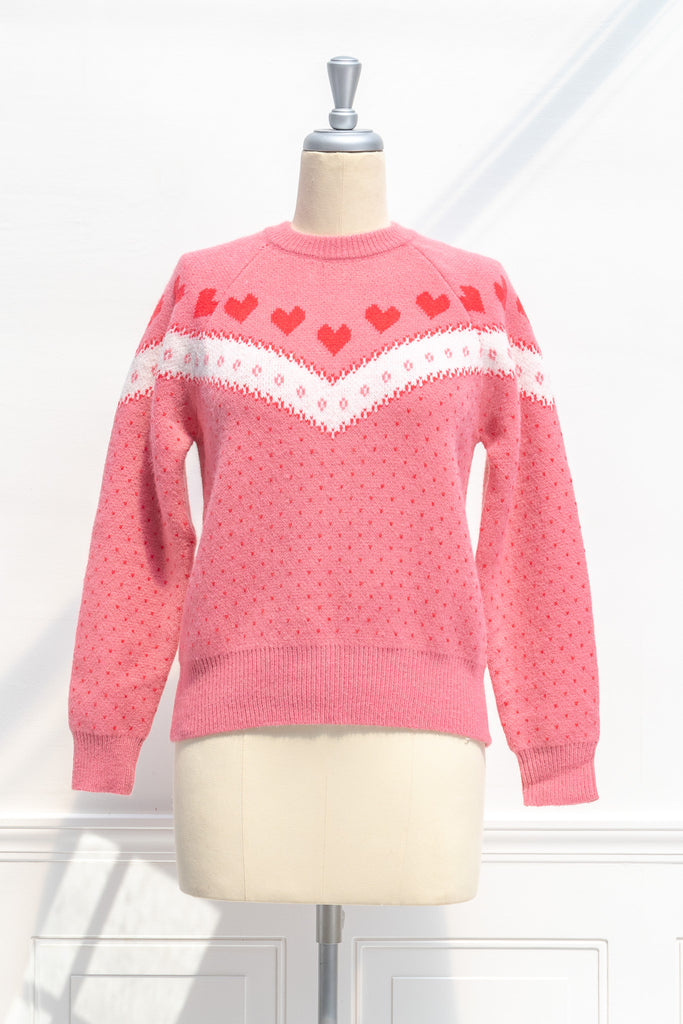 cute sweater in pink, with heart details and crew neck. strawberry color. front view. 