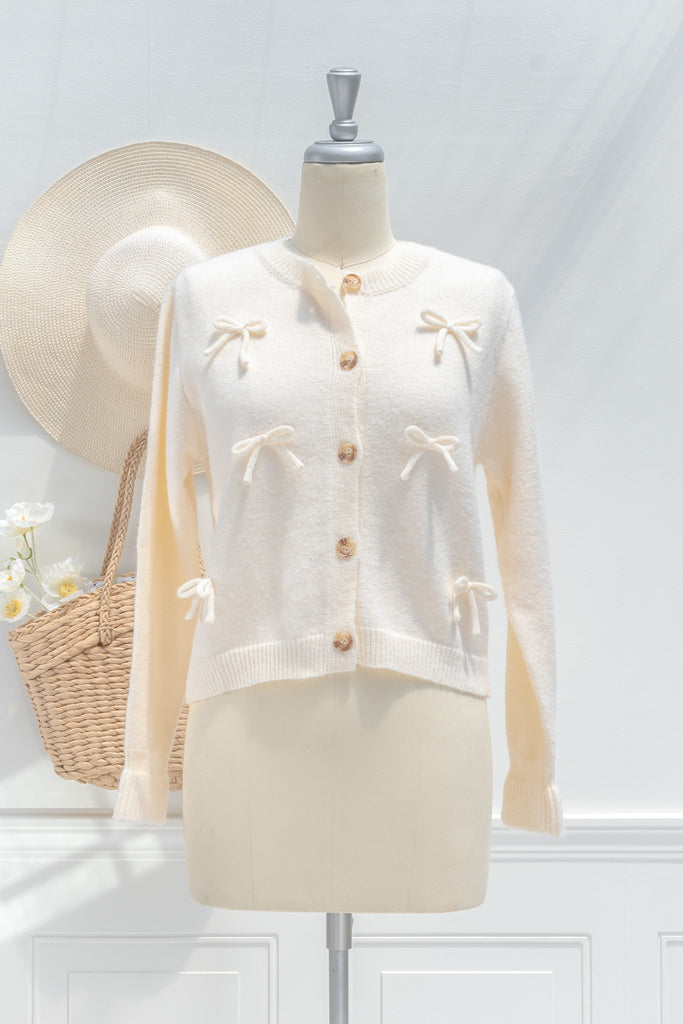 cream knit sweater with 3d bow details. front view. 