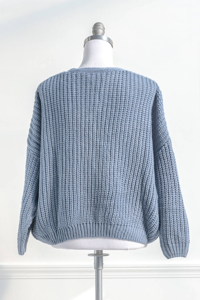 cute winter cardigan in a feminine and vintage style cut. cardigan with pockets and button down details. blue knit. back view. amantine. 