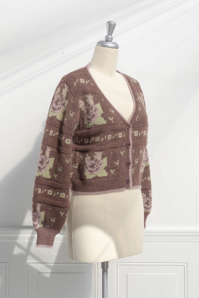 cute sweaters for fall. a floral abstract print light brown and green button down cardigan. 3/4 side view. 