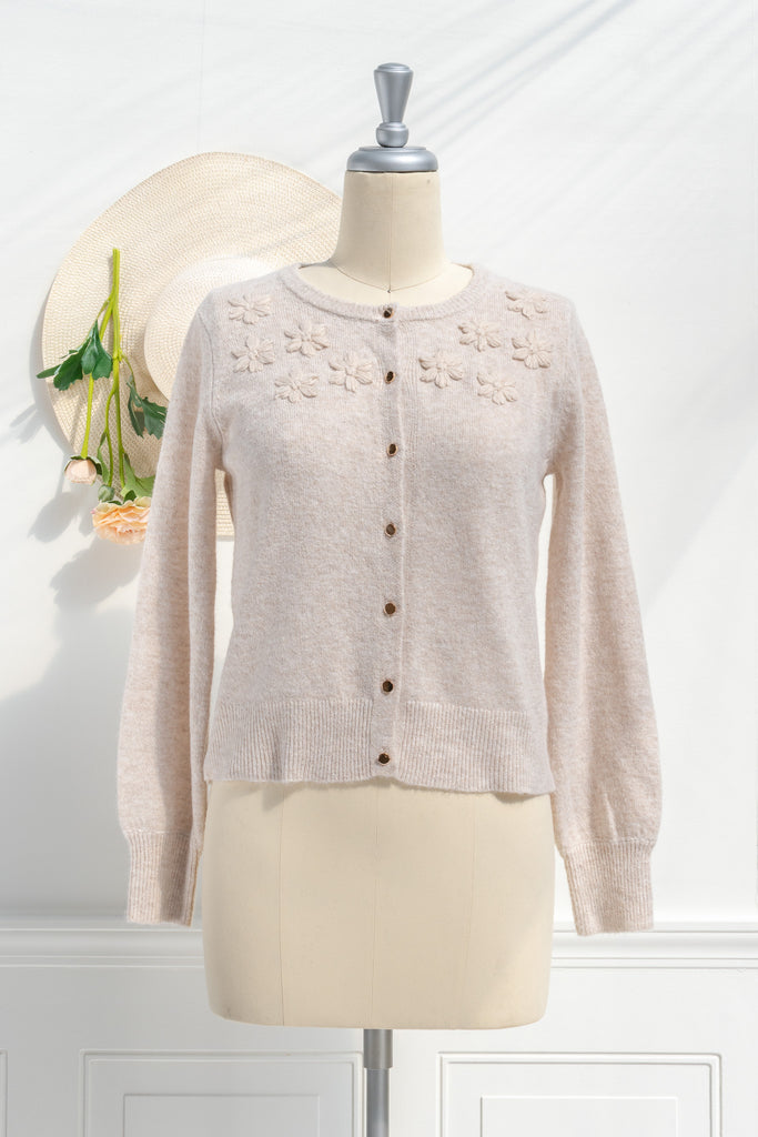 cute sweater in french and cottagecore style. features crew neck, long sleeves, pretty shiny buttons, and a relief flower embroidery above the bust. feminine cottagecore style top. front view. amantine.