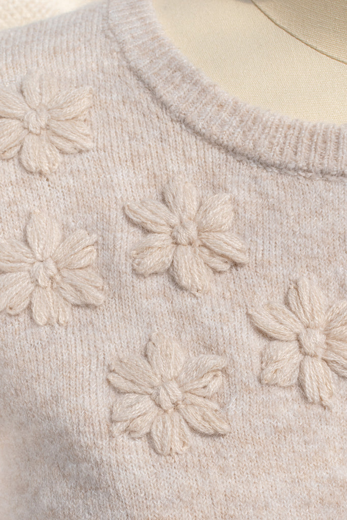 cute sweater in french and cottagecore style. features crew neck, long sleeves, pretty shiny buttons, and a relief flower embroidery above the bust. feminine cottagecore style top. 2 inch flower embroidery relief view. amantine.