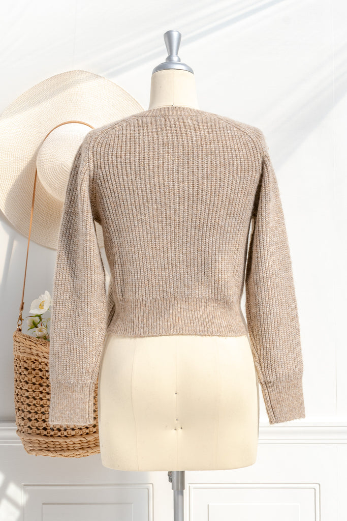 A cozy and comfy cardigan for autumn, the Isobel sweater features faux-pearl buttons, cropped length, a crew neckline, and long sleeves in a soft taupe knit. back view. 