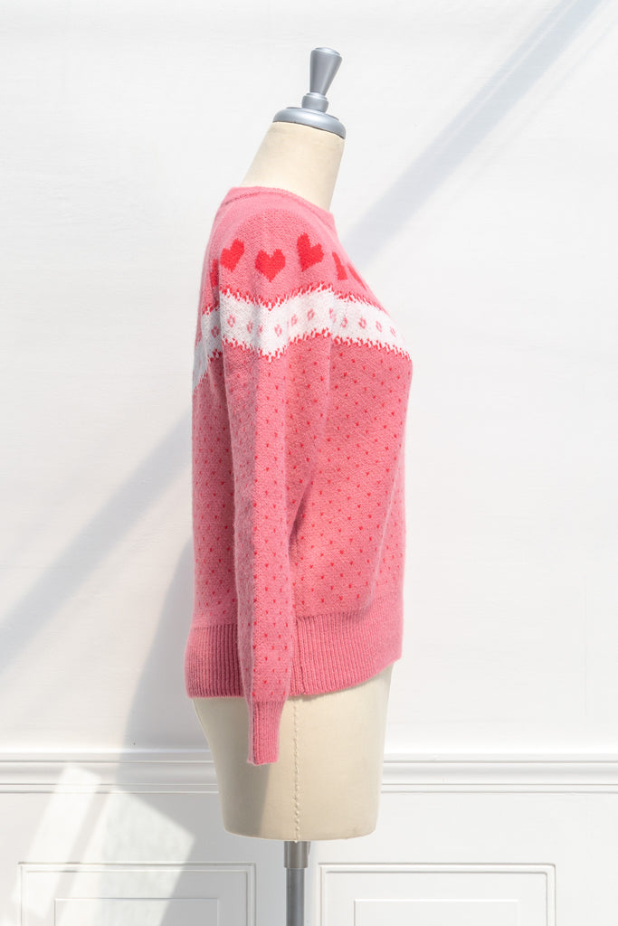 cute sweater in pink, with heart details and crew neck. strawberry color. front view. 