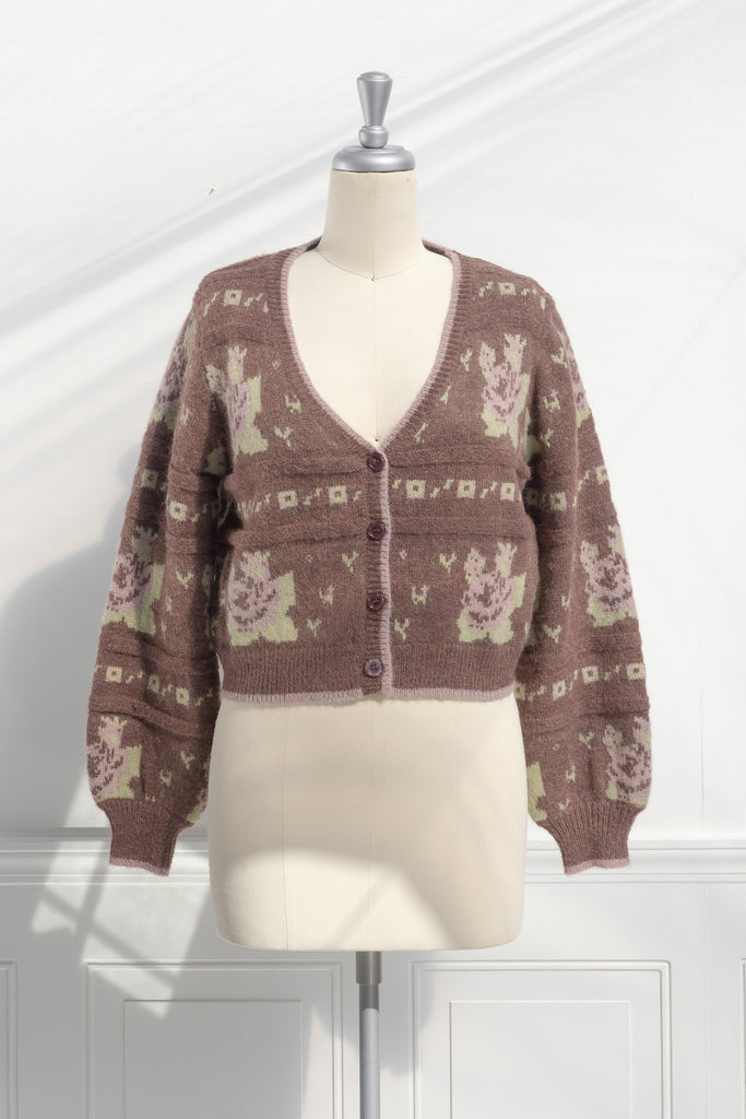 cute sweaters for fall. a floral abstract print light brown and green button down cardigan. front view. 