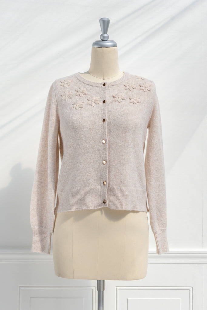 cute sweater in french and cottagecore style. features crew neck, long sleeves, pretty shiny buttons, and a relief flower embroidery above the bust. feminine cottagecore style top. front view. amantine.