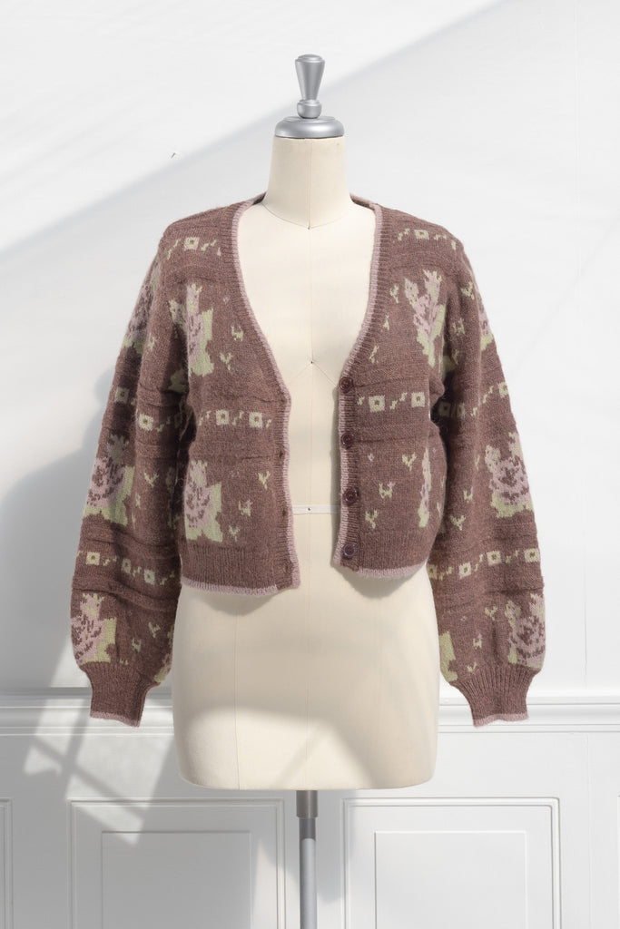 cute sweaters for fall. a floral abstract print light brown and green button down cardigan. front view. 