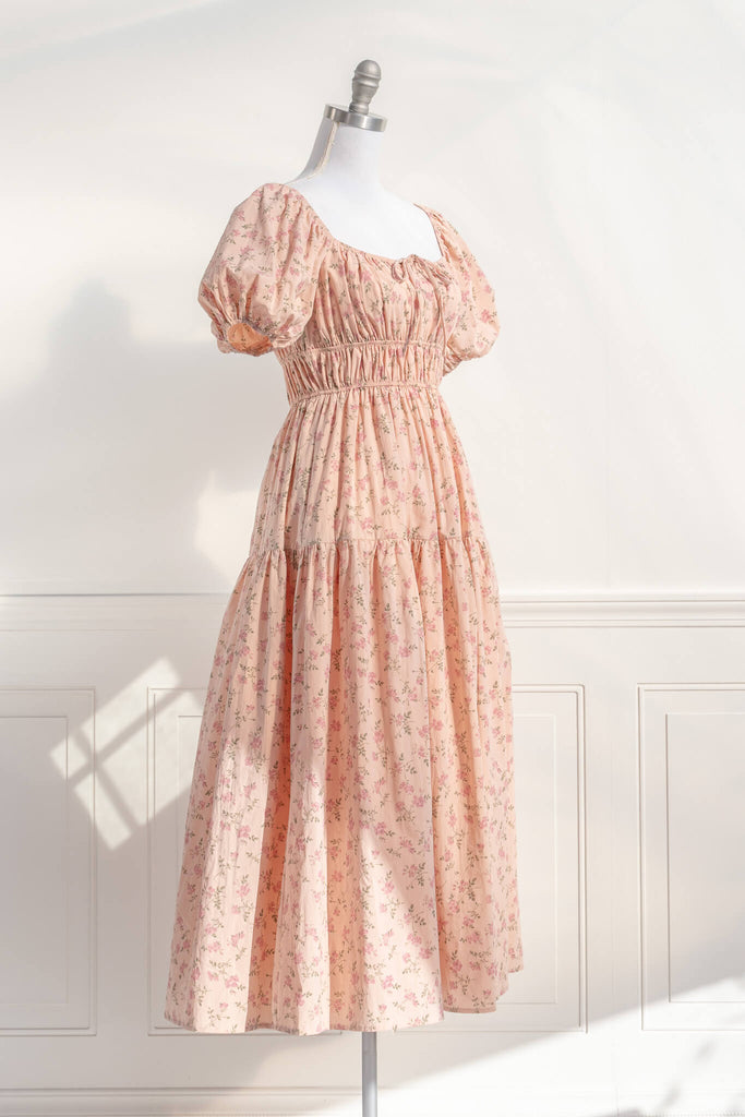 cottagecore dress / peach fuzz dress.  a beautiful floral dress for spring with a square neckline, puff sleeves, and elastic waist. perfect for cottagecore dress goals. amantine - quarter view.
