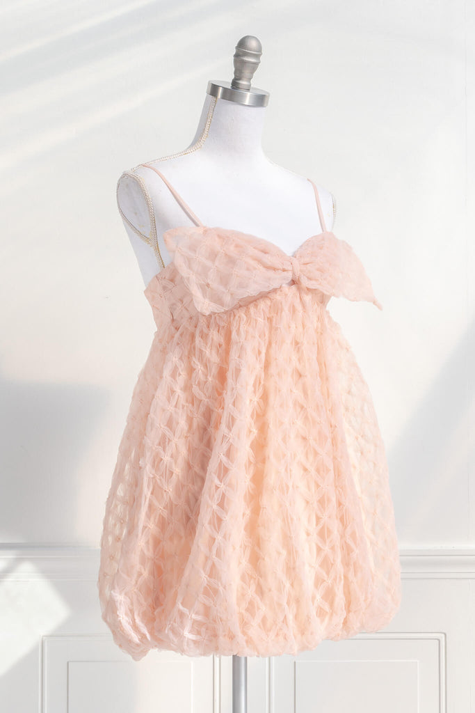 bow dress - a feminine dress with a bow in the front in pink and textured organza. Amantine. quarter View. 
