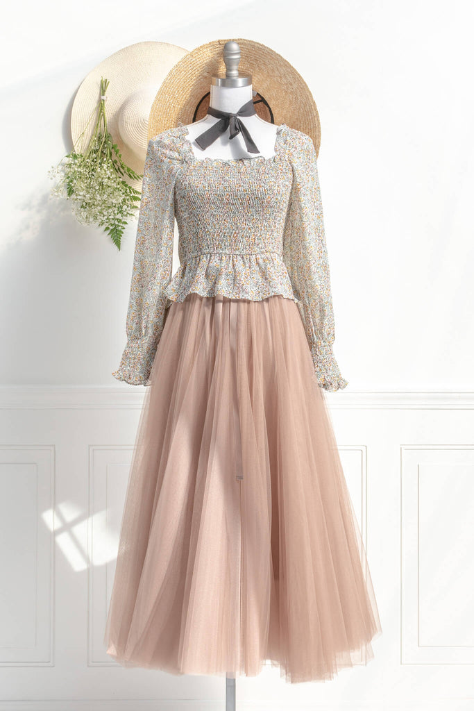 Feminine skirts - a long tulle skirt with a bow decorative closure, featuring two layers of tulle and a slip lining. amantine. styled with a feminine top for a cottagecore outfit view. 